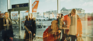 Des clients marchant dans un aéroport avec un EasyJet en fond